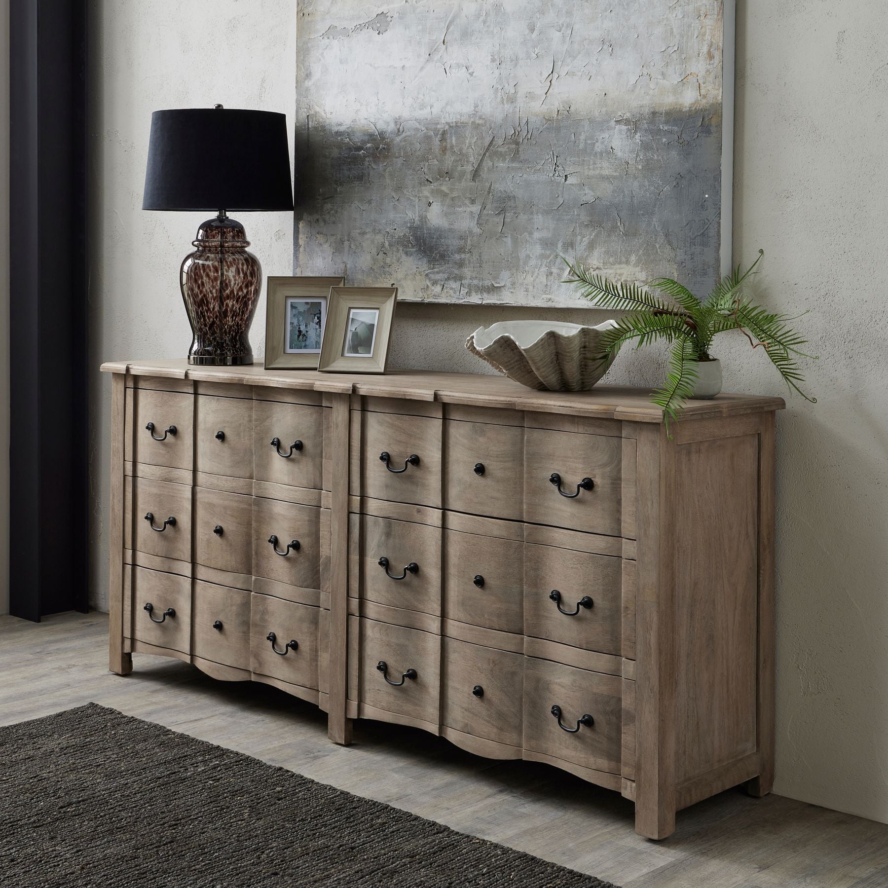Wooden dresser with decorative items in a room setting