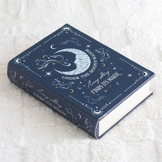 Decorative blue book with celestial design on a white textured surface