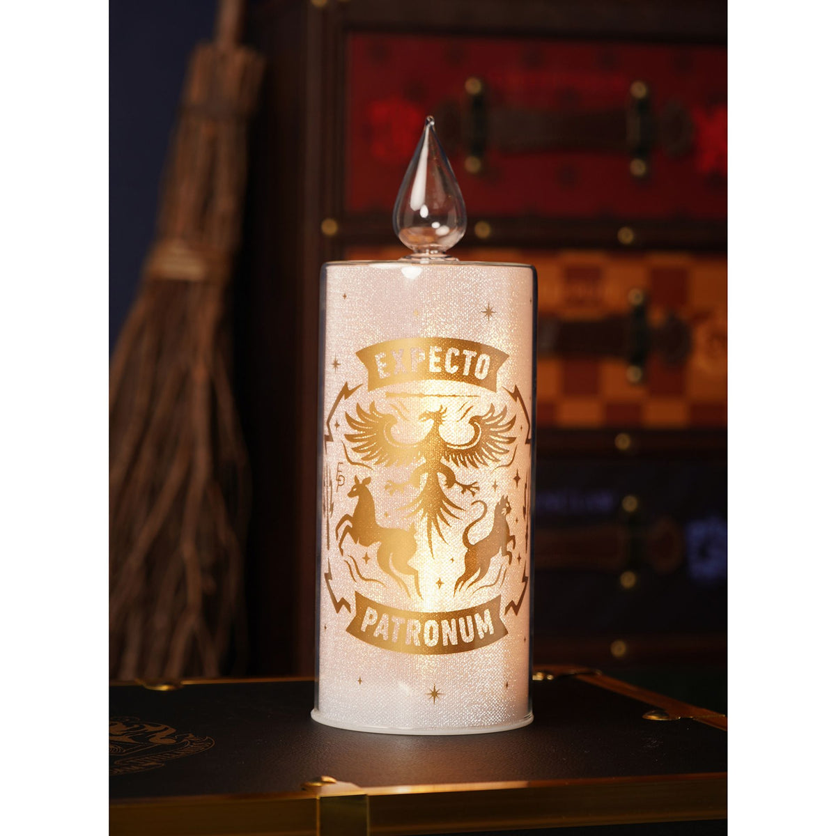 Decorative candle with 'Exspecto Patronum' text and design on a wooden surface.