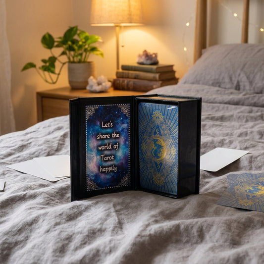 Black book with tarot card design and text on a blue fabric background